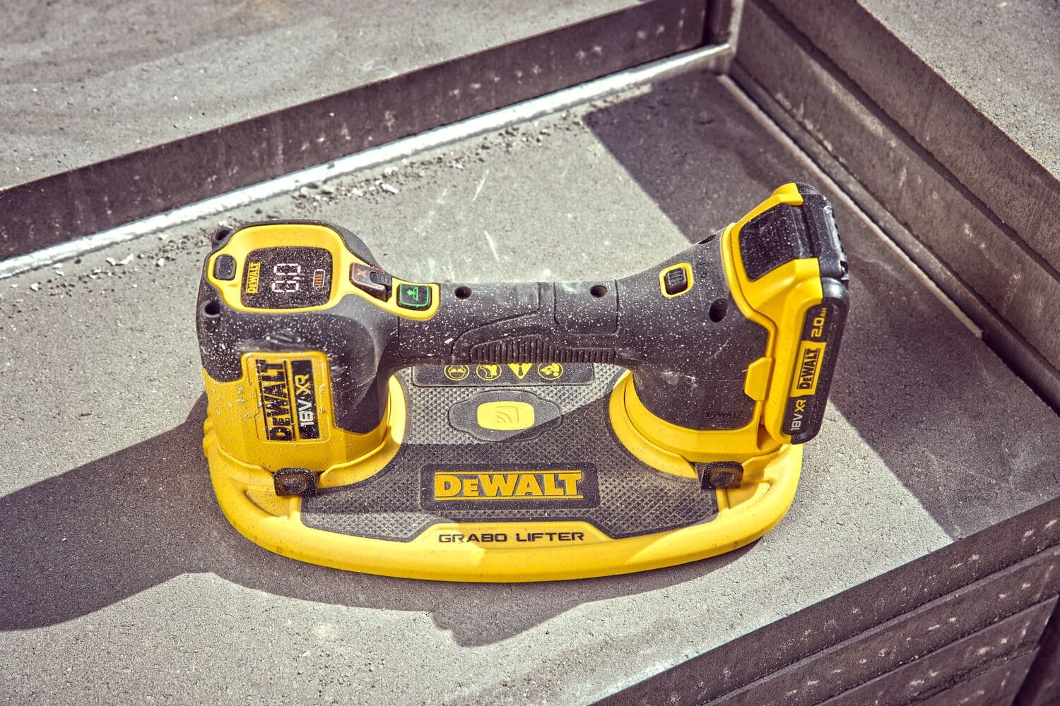 Herramienta DEWALT GRABO Lifter sobre escalones de hormigón, para levantar materiales pesados con batería.
