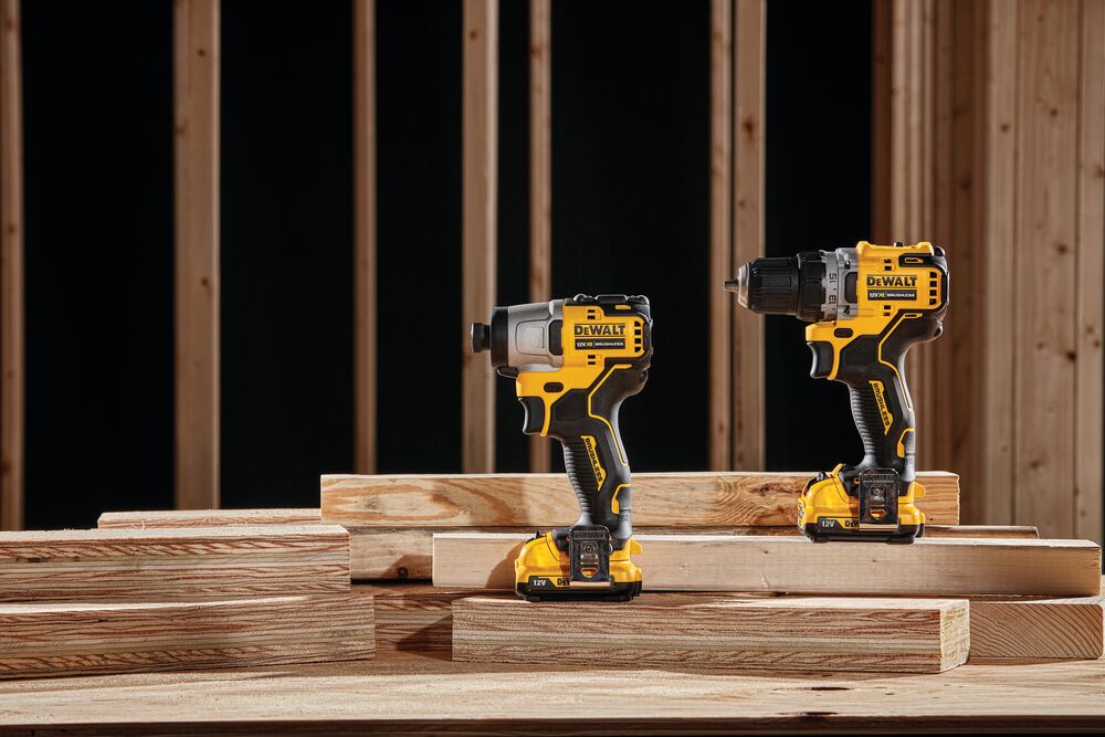 Herramientas DEWALT DCK2111L2T-XE y DCF801N sobre tablas de madera en obra en construcción.